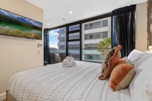 Ένα ή περισσότερα κρεβάτια σε δωμάτιο στο Marvelous Downtown Apartment Moments from Main Beach with Heated Pool, Gym and Parking