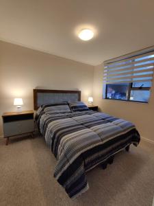 a bedroom with a large bed and a window at Depto Aromo 2D 1B factura empresas in Concepción