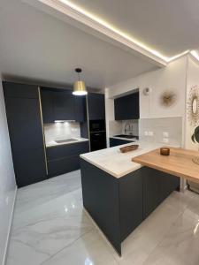 a kitchen with black cabinets and a wooden counter top at Appartement de Luxe in Villepinte