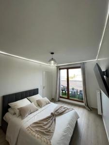 a bedroom with a large bed and a large window at Appartement de Luxe in Villepinte