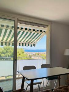 a table and chairs in a room with a large window at Blue Paradise in La Ciotat