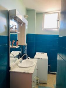 a blue bathroom with a sink and a washing machine at Blue Paradise in La Ciotat