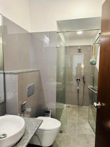 Un baño con ducha, inodoro y lavabo. en Luxe 3BR Haven at Iconic Galaxy, en Sri Jayewardenepura Kotte