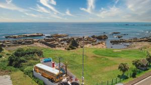 a school bus is parked next to the ocean at Hotel Ocean BUS Shirahama in Shioura