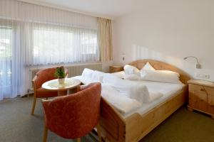 een slaapkamer met een bed en een tafel en stoelen bij Gästehaus Ahornblick in Mayrhofen