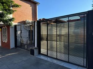 un cancello con porte scorrevoli davanti a un edificio di Casa Privada con Piscina y Parking Gratis en Asunción ad Asunción