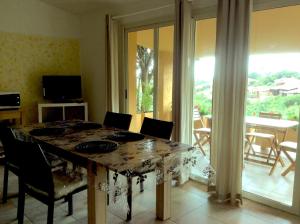uma sala de jantar com uma mesa com cadeiras e uma janela em Villetta Vista Mare em Costa Paradiso