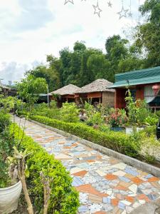 a walkway in a garden with houses in the background at Ha Giang Eco Bungalow in Ha Giang