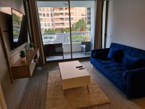 a living room with a blue couch and a coffee table at Departamento edificio rotterdam amoblado in Iquique