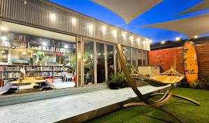 a porch with a hammock in front of a library at Cat on a Hot Tin Roof in Yangyang