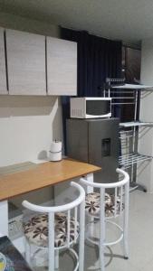 a kitchen with a table and two chairs and a microwave at Habitación Amoblada in Tacna
