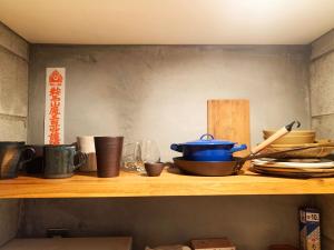 ein Regal mit einem Topf und anderen Gegenständen darauf in der Unterkunft The Moon Room in Kyoto