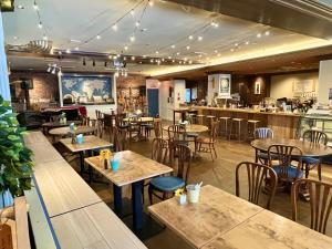 a restaurant with tables and chairs and a bar at Nawate Guesthouse in Matsumoto