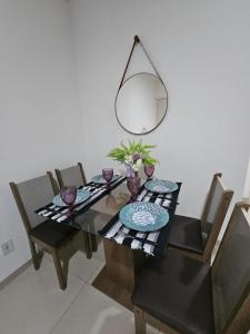 a dining room table with chairs and a mirror at Marques Beach House MCZ in Maceió