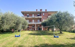 a house with a yard with swings in front of it at Lovely Apartment In Tuoro Sul Trasimeno in Tuoro sul Trasimeno