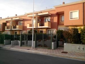 une clôture devant un bâtiment dans l'établissement Sweet Sardinia Apartment R2968, à Elmas