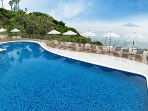 a large swimming pool with chairs and umbrellas at Irago Ocean Resort in Tahara