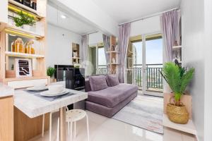 ein Wohnzimmer mit einer Couch und einem Tisch in der Unterkunft Mukava by Kozystay - Grogol in Jakarta