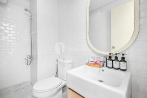 ein Badezimmer mit Toilette, Waschbecken und Spiegel in der Unterkunft Mukava by Kozystay - Grogol in Jakarta + 13 Fotos