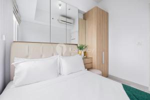 ein Schlafzimmer mit einem großen weißen Bett mit weißen Kissen in der Unterkunft Mukava by Kozystay - Grogol in Jakarta