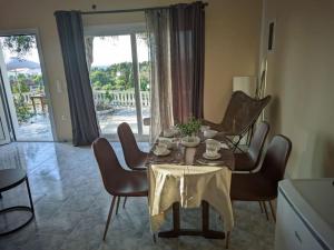 a dining room with a table and chairs and a glass door at Blue Horizon in Corfu