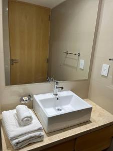 ein Badezimmer mit Waschbecken, Spiegel und Handtüchern in der Unterkunft Apartamento céntrico con las mejores vistas de Mendoza in Mendoza