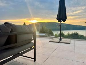 a patio with an umbrella and a bench and a view at Vila Valkov in Bžany
