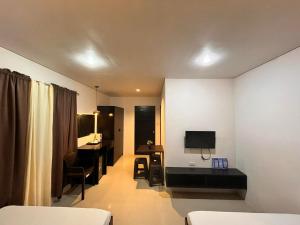 a room with a bed and a desk and a television at Casita Isla Beach Inn in Boracay