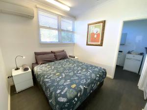 埃克斯茅斯Getaway Villas Unit 3812的一间卧室配有一张带绿色棉被的床