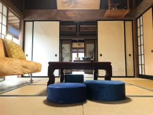 sala de estar con mesa y taburetes azules en 農家民宿　佐京園, en Shimada