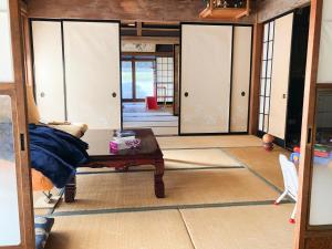 sala de estar con mesa y algunas puertas correderas en 農家民宿　佐京園, en Shimada