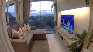 ein Wohnzimmer mit Couch und großem Fenster in der Unterkunft Rocco 513 - Corner 1 bedroom Serviced Apartment with Seaview in Ao Nang 