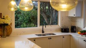 een keuken met een spoelbak en een raam bij Coachwood Cottage in Robertson +25 foto's