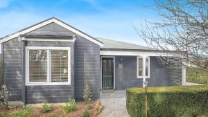 een huis met een grijze gevelbekleding bij Coachwood Cottage in Robertson