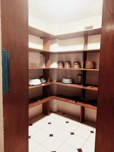 a kitchen with brown cabinets and plates on shelves at CasonaPalmira in Cuernavaca