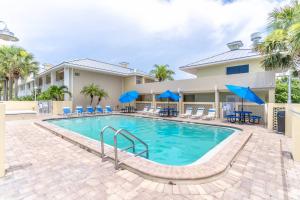 una piscina con sillas y sombrillas azules en 615 Little Harbor, en Ruskin
