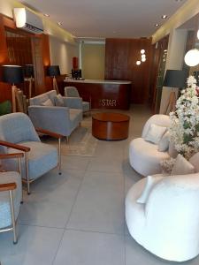 a waiting room with couches and chairs and a table at Hotel Star Islamabad in Islamabad