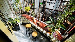 an overhead view of a balcony with plants and stools at Lotus en Laine Maison de Hanoi - Stunning Full Three Story House with Balcony in Hanoi