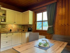 a kitchen with a wooden table and a window at Hallmoosgut in Sankt Johann im Pongau