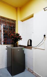 a kitchen with a refrigerator with a vase of flowers on it at Lotus en Laine Maison de Hanoi - Stunning Full Three Story House with Balcony in Hanoi