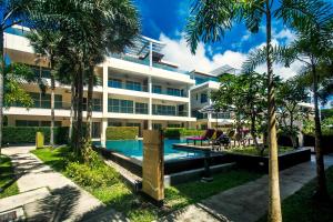 an apartment building with a swimming pool and palm trees at Krabi Luxury Penthouse in Klong Muang Beach