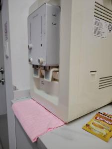 雪邦Tangerine Suite to KLIA within 12Min的微波炉放在柜台上，上面铺着一条粉色毛巾