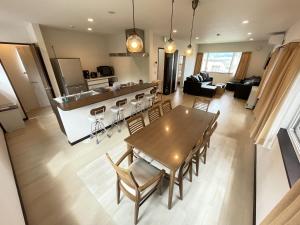 富良野SORA 1的配有木桌椅的厨房和客厅