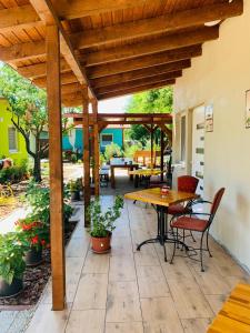 a patio with a wooden pergola and a table and chairs at Arvisura Vendégházak family and pet friendly apartments in Zsombó