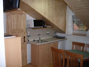 eine kleine Küche mit einer Spüle und einer Mikrowelle in der Unterkunft Penzion U Heřmánků Volary in Volary