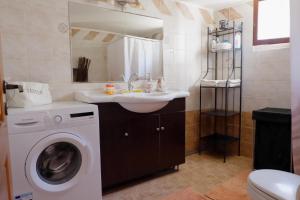 a bathroom with a washing machine and a sink at Aeneo Studio 2 in Symi
