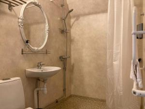 Madam Blå Hotel في Nossebro: حمام مع حوض و مرآة و مرحاض +24 صورة