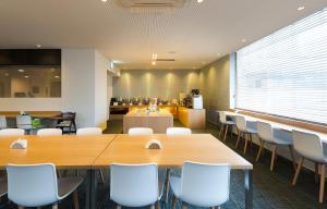 a conference room with wooden tables and white chairs at Metro Hotel Myeongdong in Seoul