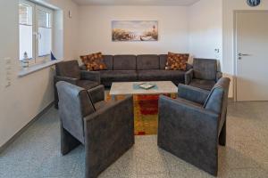 a living room with a couch and chairs and a table at Ferienhaus Domingo in Bensersiel