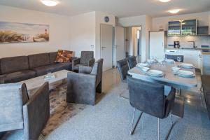 a living room with a table and chairs and a couch at Ferienhaus Bellevue in Bensersiel